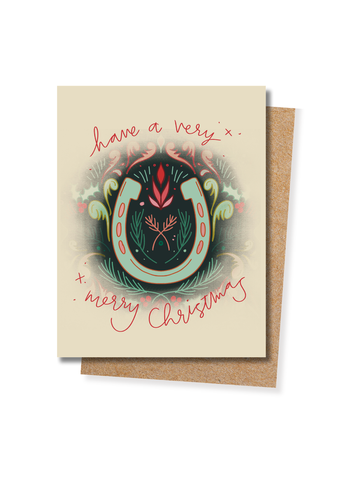 Have a Very Merry Christmas card in cream, featuring a horseshoe wrapped in holly and florals, with a kraft envelope