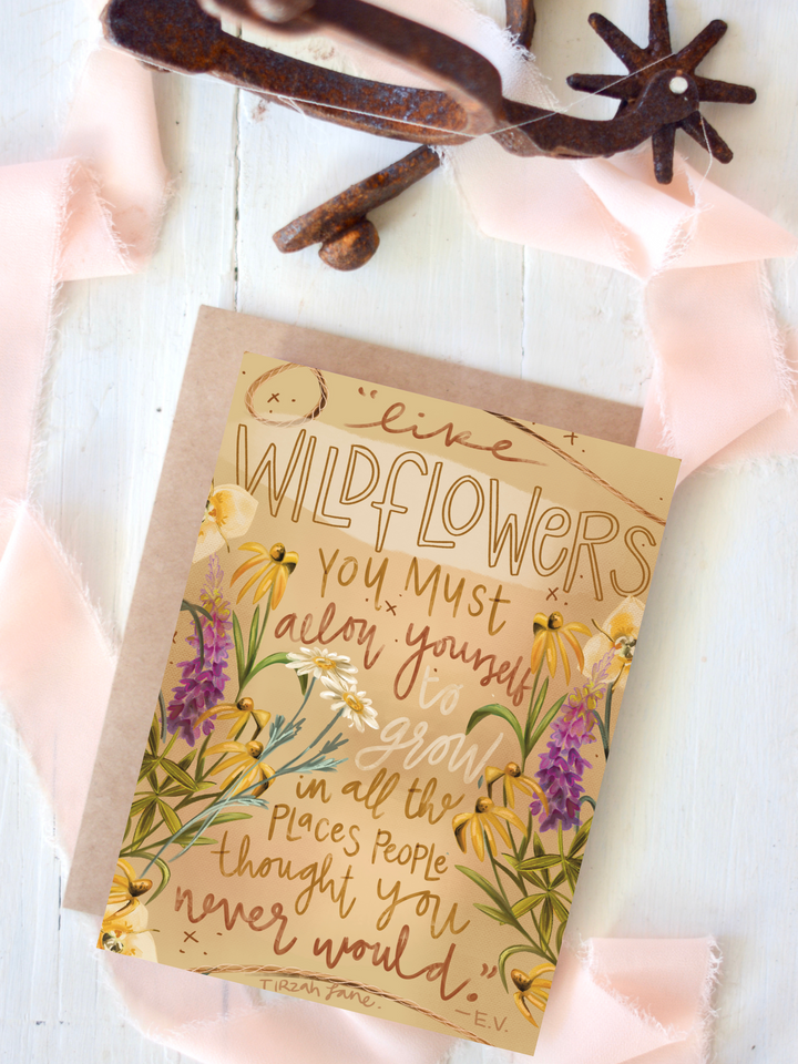 Allow Yourself to Grow card featuring hand-lettering surrounded by purple and yellow wildflowers, styled with spurs and blush ribbon