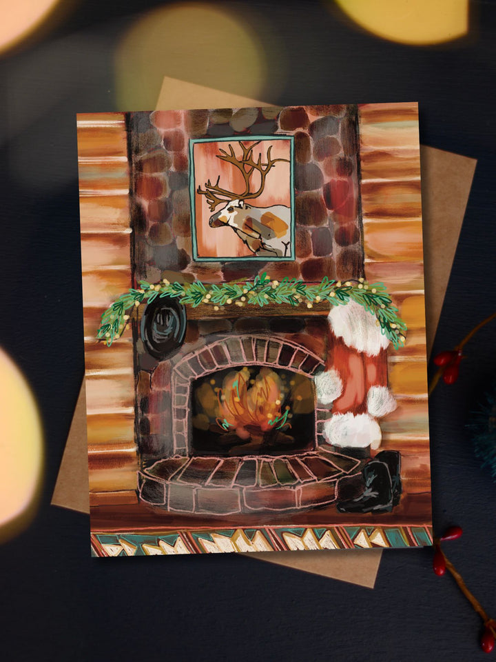 Santa's Cabin Christmas card featuring a cozy stone fireplace with stockings and a wreath